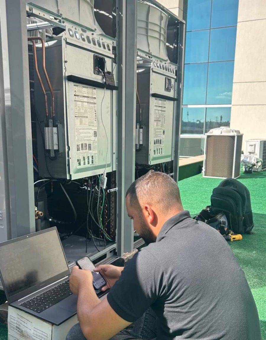 Técnico da SC Soluções Engenharia fazendo diagnóstico em unidade de climatização com notebook